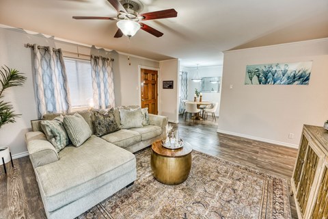 a living room with a couch and a ceiling fan